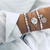 Silver bead and chain bracelet stack with round disc charm on a wrist