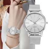 Silver mesh watch with white dial worn on a wrist beside a larger matching watch