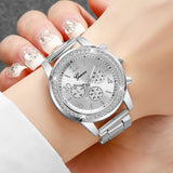 Silver rhinestone watch with white dial and steel bracelet worn on a wrist
