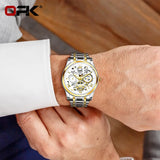 Silver OPK skeleton watch with white dial worn on a wrist