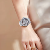 Close view of silver snowflake dial watch with crystal bezel worn on a wrist