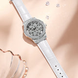 Silver crystal watch with snowflake dial and white strap styled beside gold bangles