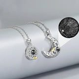 Silver sun and moon pendant necklaces with projection stone displayed on a stand