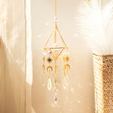 Crystal prism suncatcher hanging in a bright window beside a sheer curtain