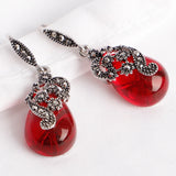 Silver vintage style drop earrings with red teardrop stones and marcasite detail