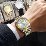 Two-tone silver and gold luxury watch worn on wrist with a suit sleeve