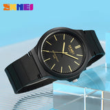 Black case watch with black dial shown against a blue geometric background