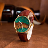 Wooden watch with teal dial and brown leather strap shown close up