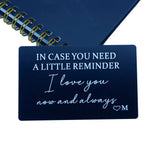 Engraved black wallet insert card resting on a notebook with a gold spiral binding