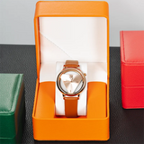 Orange PU leather watch case open showing a brown leather strap watch up close