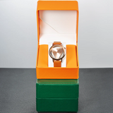 Orange PU leather watch case open displaying a watch against a dark background