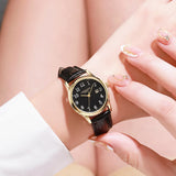 Gold case women's watch with black dial held in a hand