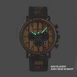Two-tone wooden chronograph watch shown with glowing luminous hands on grey background