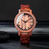 Red sandalwood watch with pale dial and wooden link bracelet on grey fabric