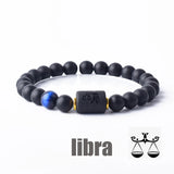 Dark stone bead bracelet with Libra zodiac symbol charm on white background