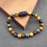 Natural stone bead zodiac bracelet resting against a light wood block