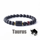 Dark stone bead bracelet with Taurus zodiac symbol charm