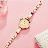 Close-up of slim rose gold watch bracelet on a pink styled background