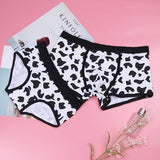 Black and white heart print cotton couples underwear displayed on a pink background