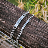 Close view of silver engravable ID bar bracelet resting on weathered wood