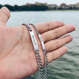 Hand wearing silver engravable bracelet with a second matching bracelet nearby
