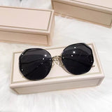 Black frame curved sunglasses with dark lens displayed in cream gift box