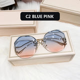 Gold frame curved sunglasses with blue to pink gradient lens in cream box