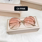 Gold frame curved sunglasses with pink gradient lens in cream box