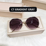 Gold frame curved sunglasses with gray gradient lens in cream box