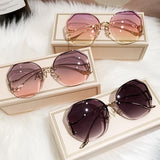 Two curved sunglasses with gradient lenses displayed together in cream box
