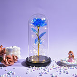 Multicolour galaxy rose in a glass dome with LED lights on a wooden base