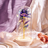 Multicolour galaxy rose in a lit glass dome against an orange background