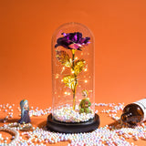 Purple galaxy rose glowing under a glass dome with fairy lights on a dark base